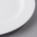 A close up of a Libbey round white porcelain plate with a medium rim.