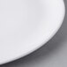 A close up of a Libbey white porcelain coupe plate with a white rim.