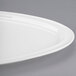 A close up of a Libbey white porcelain triform plate with curved edges.