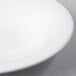 A Libbey Royal Rideau white porcelain bowl with a small amount of food in it.