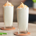 Two glasses of Cappuccine Supreme Coconut Frappe with whipped cream and sprinkles on top.