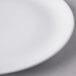 A close up of a Libbey white porcelain coupe plate with a white rim.