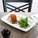 A white rectangular Libbey Slenda porcelain plate with salmon and green beans on a table.