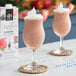 Two glasses of wildberry smoothie with strawberries and blueberries on a white background.