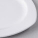 A close up of a Libbey white porcelain square plate with a small rim.