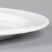 A close up of a Libbey white porcelain plate with a medium rim.