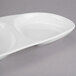 A white oval serving plate with three circular wells.