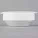 A white bowl with two handles on a gray surface.