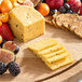 Beemster Hatch Pepper Gouda cheese and fruit on a wooden board.