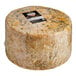 A large Coombe Castle Blue Stilton cheese wheel with a label on it.