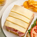 A sandwich with ham and Ammerlander Smoked Gouda cheese on a plate.