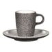 A RAK Porcelain espresso cup and saucer with a speckled surface on a table.