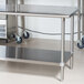 A white rectangular Advance Tabco stainless steel work table with a stainless steel undershelf.