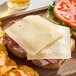 A sandwich with Ammerlander Havarti cheese and ham on a plate.