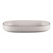 A white oval RAK Porcelain deep porcelain plate with speckled specks on a white counter.