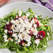 A white plate with a salad of beets and goat cheese.