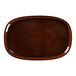 A brown oval porcelain plate with a white background.