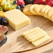 A wooden board with Ammerlander Butterkase cheese, fruit, and crackers.