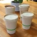 World Centric compostable bamboo hot cup lids on three white cups on a table.