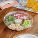 A clear Inline Plastics plastic tray with vegetables and dip on a table.