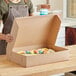 A woman holding a Southern Champion Bakery Box with a cake inside.