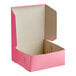 A pink Southern Champion bakery box with the lid open.