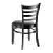 A Lancaster Table & Seating black wooden ladder back chair with a black cushion on the seat.