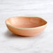 An Acopa Highlands china bowl with a pink rim on a marble surface.