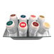 A stainless steel tray with eight squeeze bottles in it.