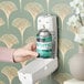 A hand holding a F-Matic Fresh Linen Scent metered air freshener refill can.
