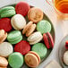 A plate of Macaron Centrale vegan classic macarons with a cup of tea on a table.