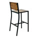 A BFM Seating black powder-coated steel barstool with a wood seat and back.