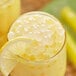 A glass of yellow liquid with Bossen Sour Lemon Bursting Boba and a lemon slice.
