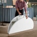 A man folding a white Lancaster Table & Seating plastic table.