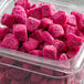 A plastic container of Pitaya Foods IQF natural dragon fruit snack-sized pieces.