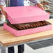 A woman opening a pink Southern Champion Bakery Box.