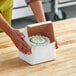 A person holding a Southern Champion cake in a box.