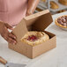 A person cutting a pie into a Southern Champion pie box.