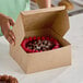 A person holding a Southern Champion bakery box with a cake inside.