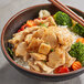 A bowl of Tindle plant-based chicken, rice, and vegetables with chopsticks.