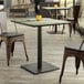 A Lancaster Table & Seating Excalibur table and chair on a wood deck.
