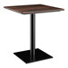 A Lancaster Table & Seating square table with a walnut top and black base plate.