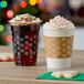 Two Choice snowflake PET plastic cups filled with whipped cream-topped coffee on a table with cookies.