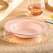A pink plastic bowl with a gold vintage rim.