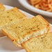 A plate of spaghetti with garlic bread on it.