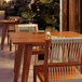 A Lancaster Table & Seating Tigerwood outdoor table with chairs made of Brazilian cherry wood and nautical rope.