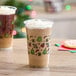 Two Choice holiday plastic cups filled with festive drinks on a table.