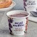A cup of Acai Exotic Hazelnut Cocoa Spread on a table with a spoon.