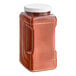 A brown plastic container of Badia Paprika with a white lid and handle.