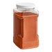 A plastic container of red cayenne pepper powder.